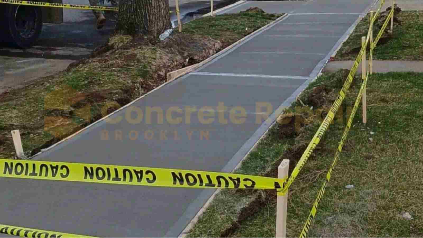Freshly Poured concrete sidewalk section with caution tape around it.