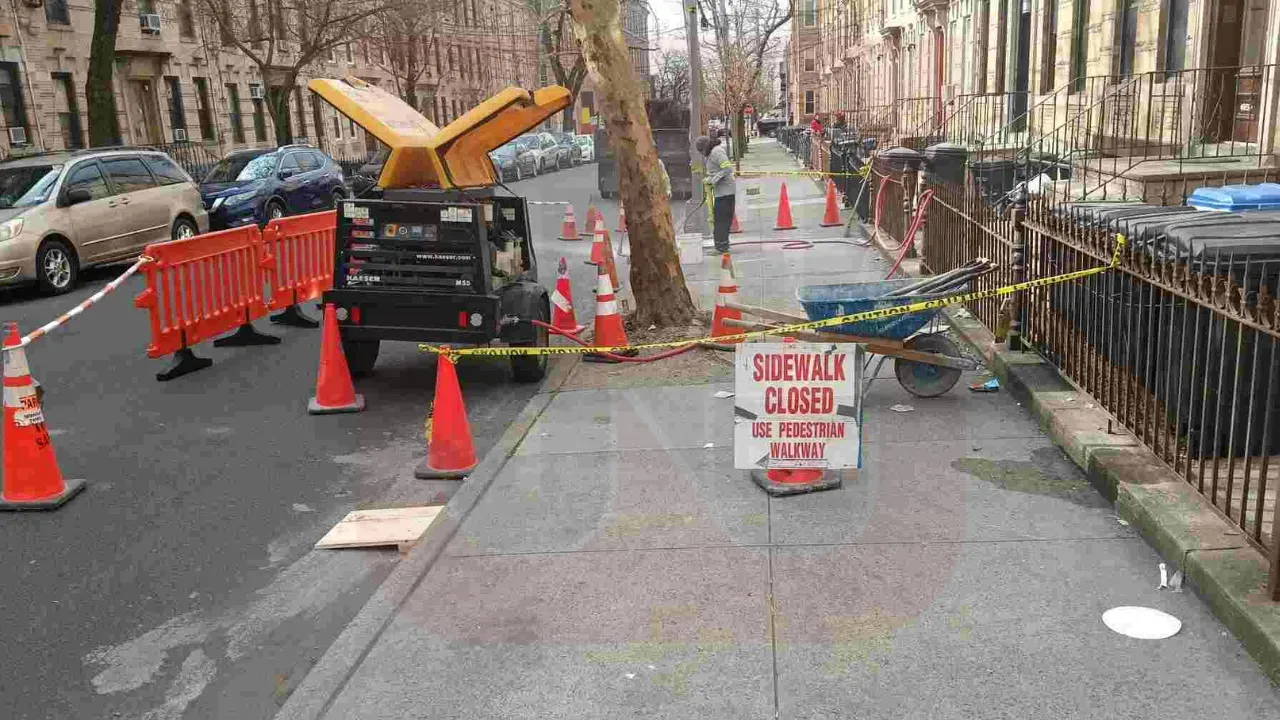 An orange-coned construction site with excavators, concrete mixers, and dump trucks was a clear indication of active sidewalk work in progress